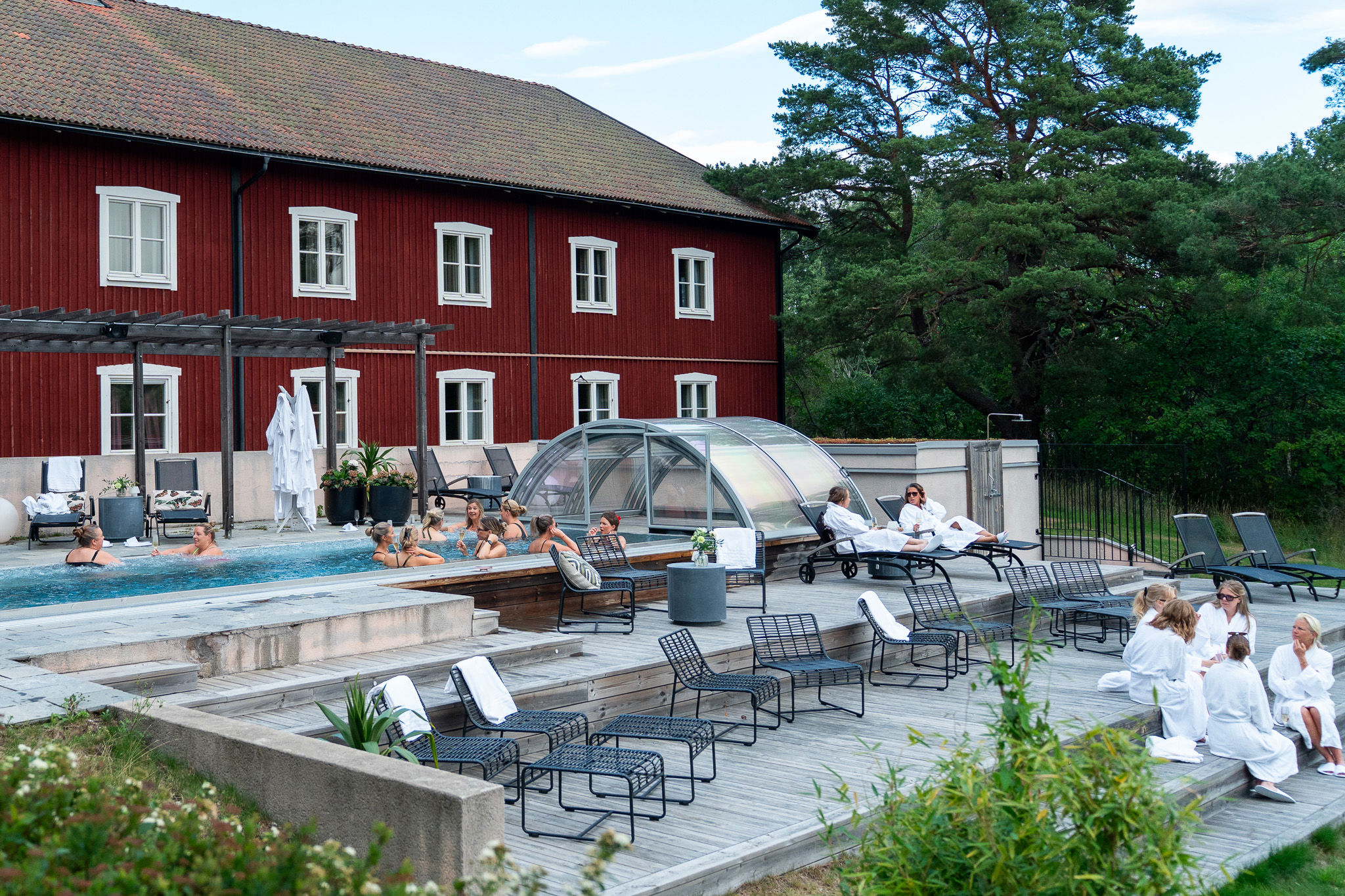 Utomhuspool med pooldäck och flera dagbäddar.