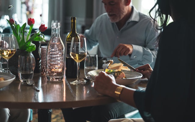 Två personer äter middag i hotellets matsal