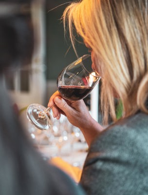 Kvinna gör en vinprovning och doftar på vinet