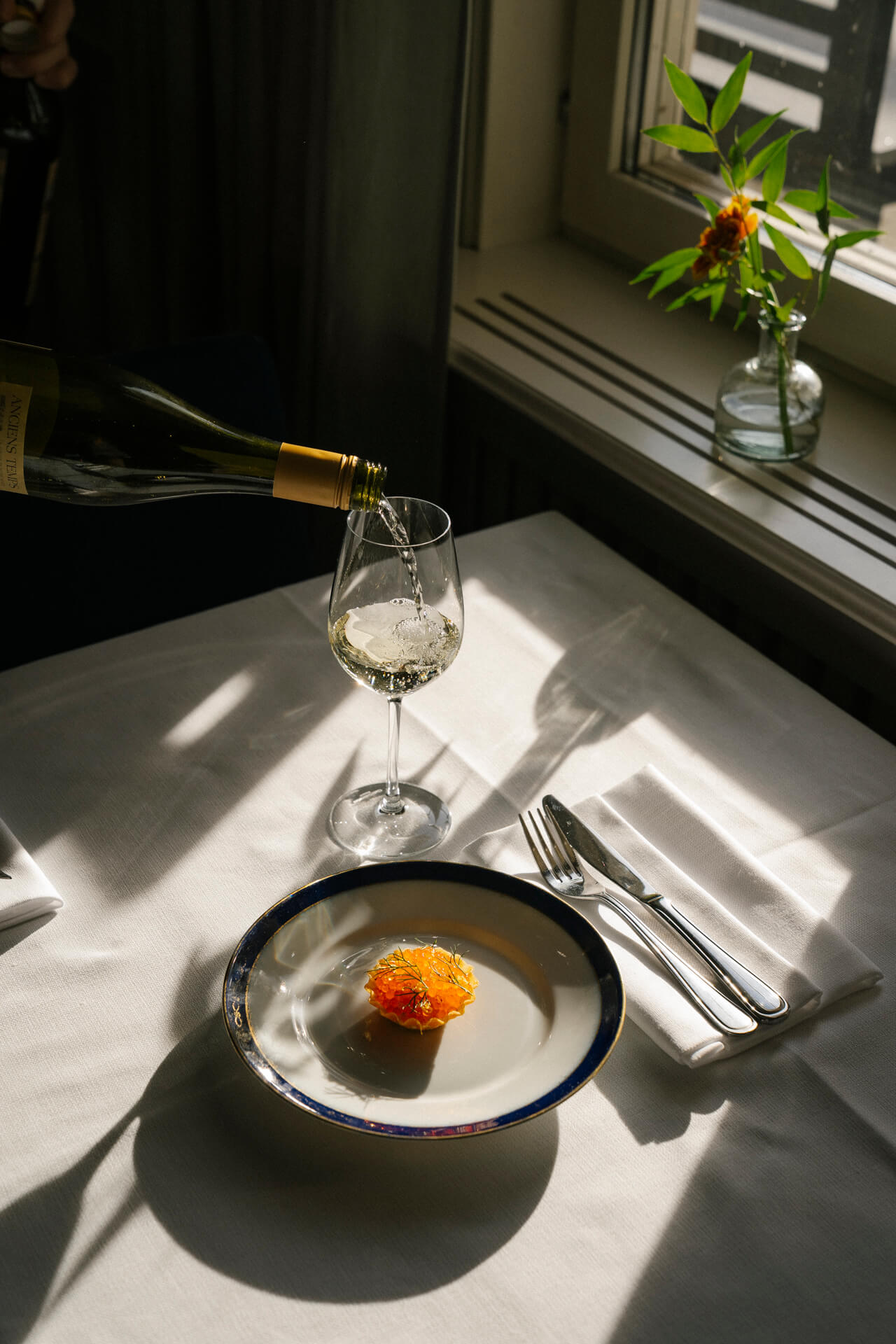 Förrätt med löjrom serveras med ett glas vitt vin