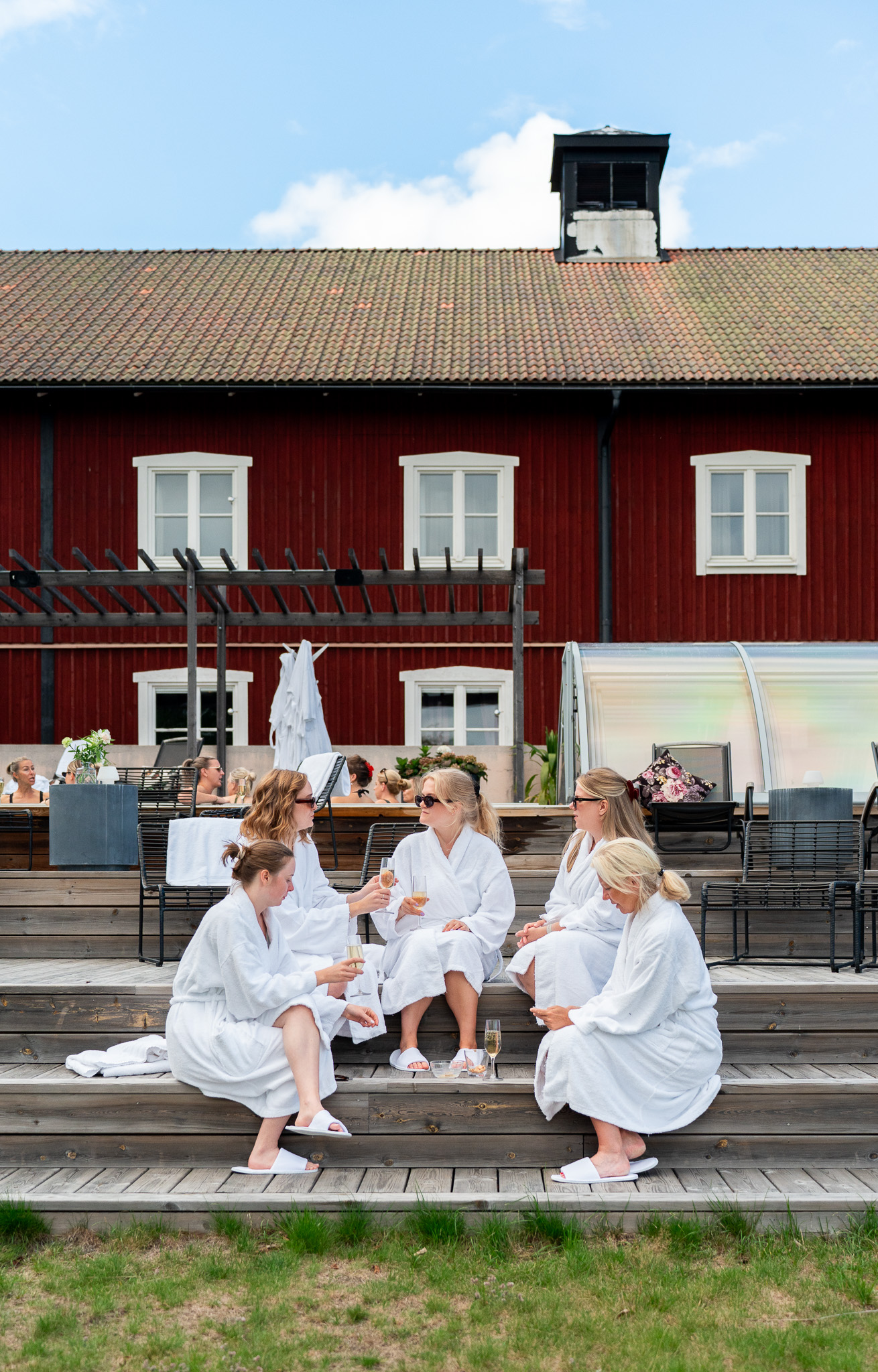 En grupp tjejer sitter vid poolen