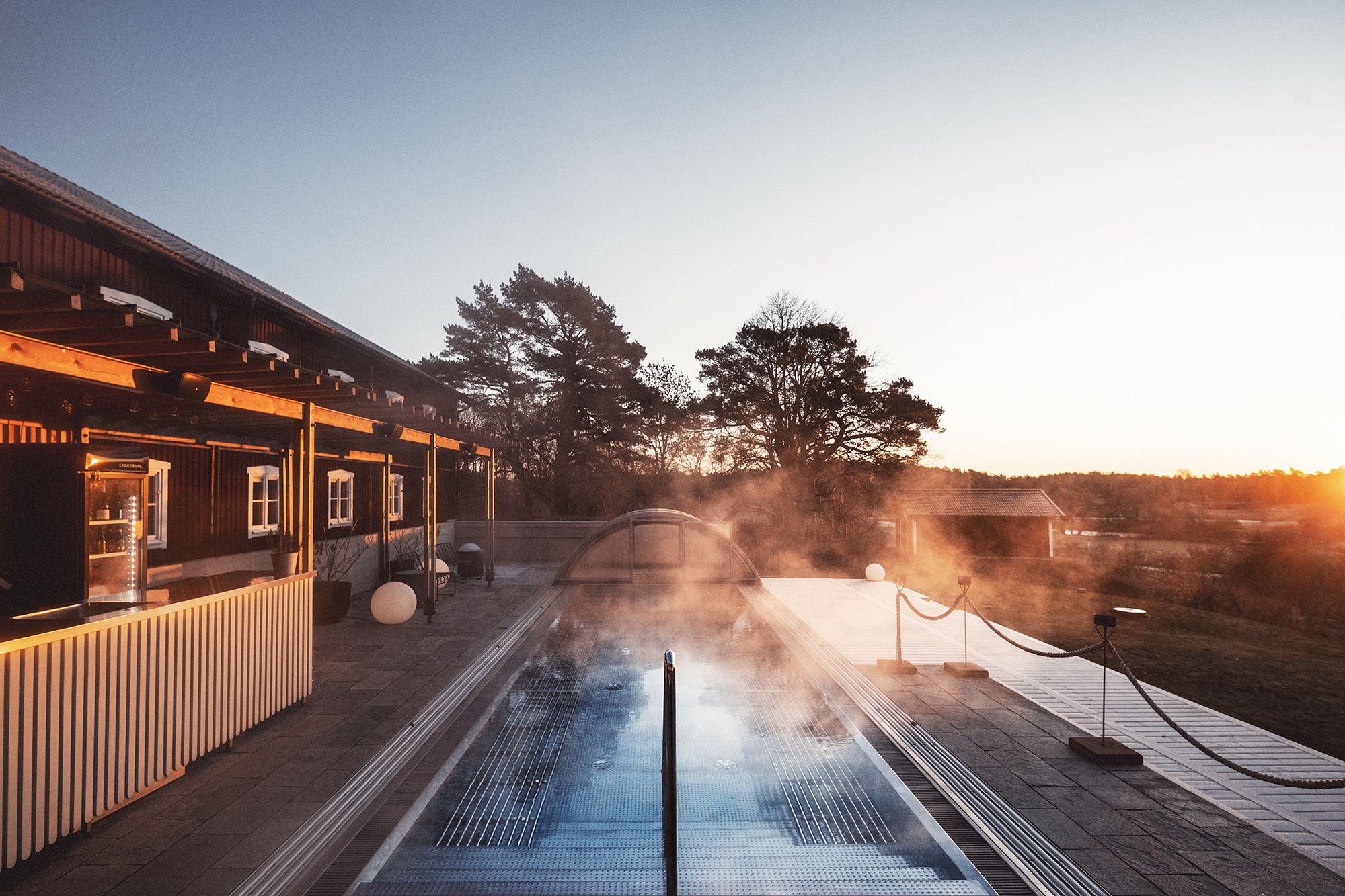 Ånga syns ovanför den varma utomhuspoolen en kylig höstdag