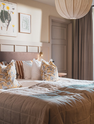 Bäddad hotellsäng i ett rum med tillhörande balkong