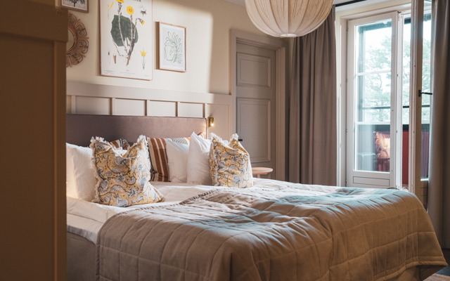 Bäddad hotellsäng i ett rum med tillhörande balkong