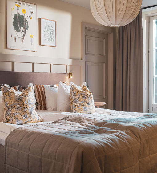 Bäddad hotellsäng i ett rum med tillhörande balkong