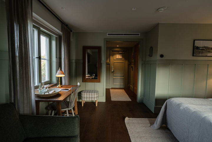 Hotellrum med väggar i gröna nyanser
