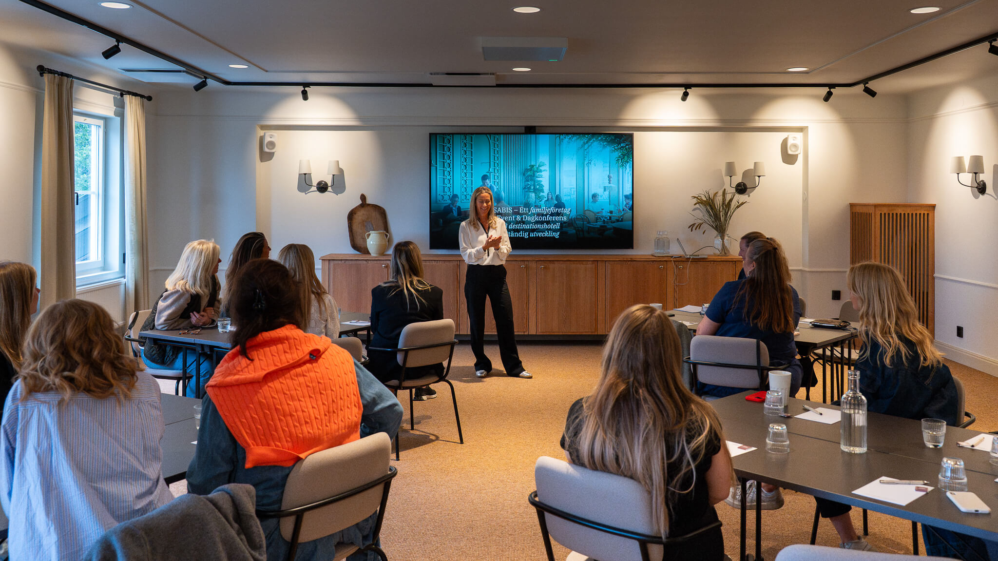 En konferensgrupp som lyssnar på föreläsning i möteslokal