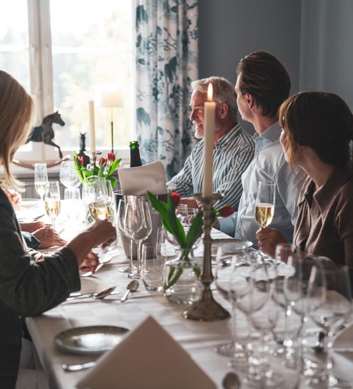 En grupp med människor sitter vid matbordet i hotellets restaurang