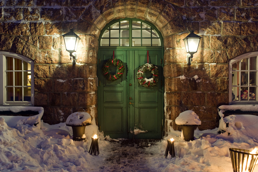 Snö ligger framför den gröna porten på hotellet