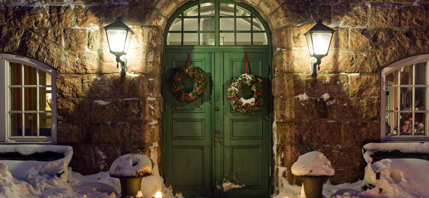 Snö ligger framför den gröna porten på hotellet