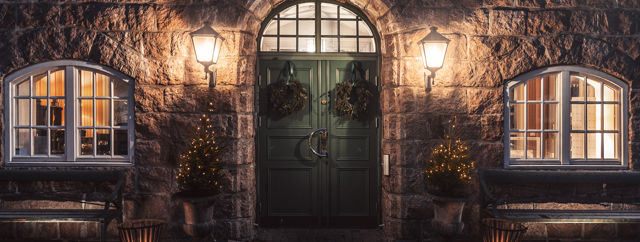 Grön dörr på stenbyggnad när det skymmer