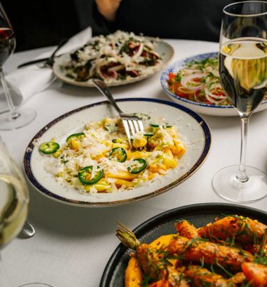 Dirty fries, kryddade morötter och tomatsallad på ett dukat lunchbord