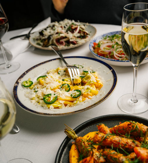 Dirty fries, kryddade morötter och tomatsallad på ett dukat lunchbord