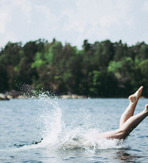 En person dyker i havet ute i skärgården