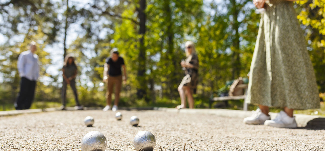Människor spelar boule i trädgården