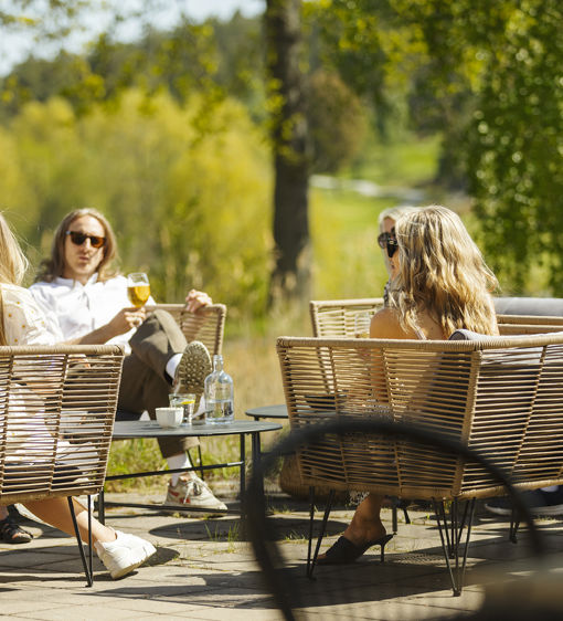 Människor sitter i loungemöbler utomhus 