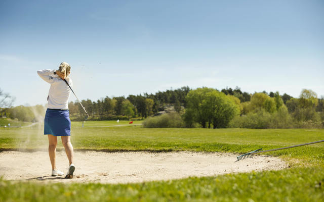 Kvinna spelar golf