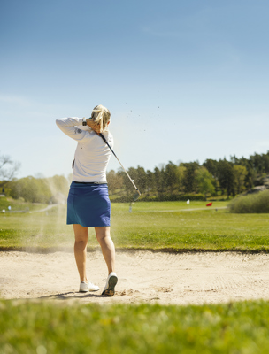 Kvinna spelar golf