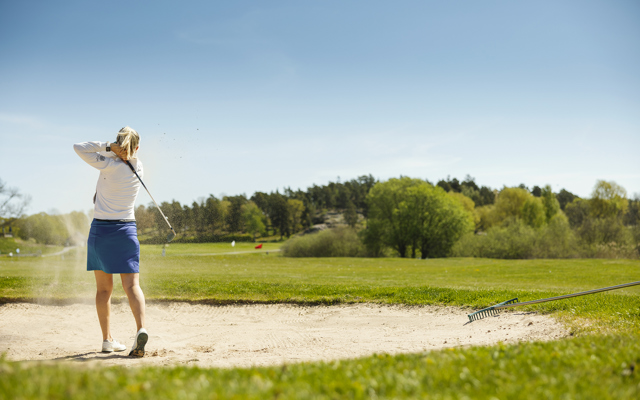 Kvinna spelar golf