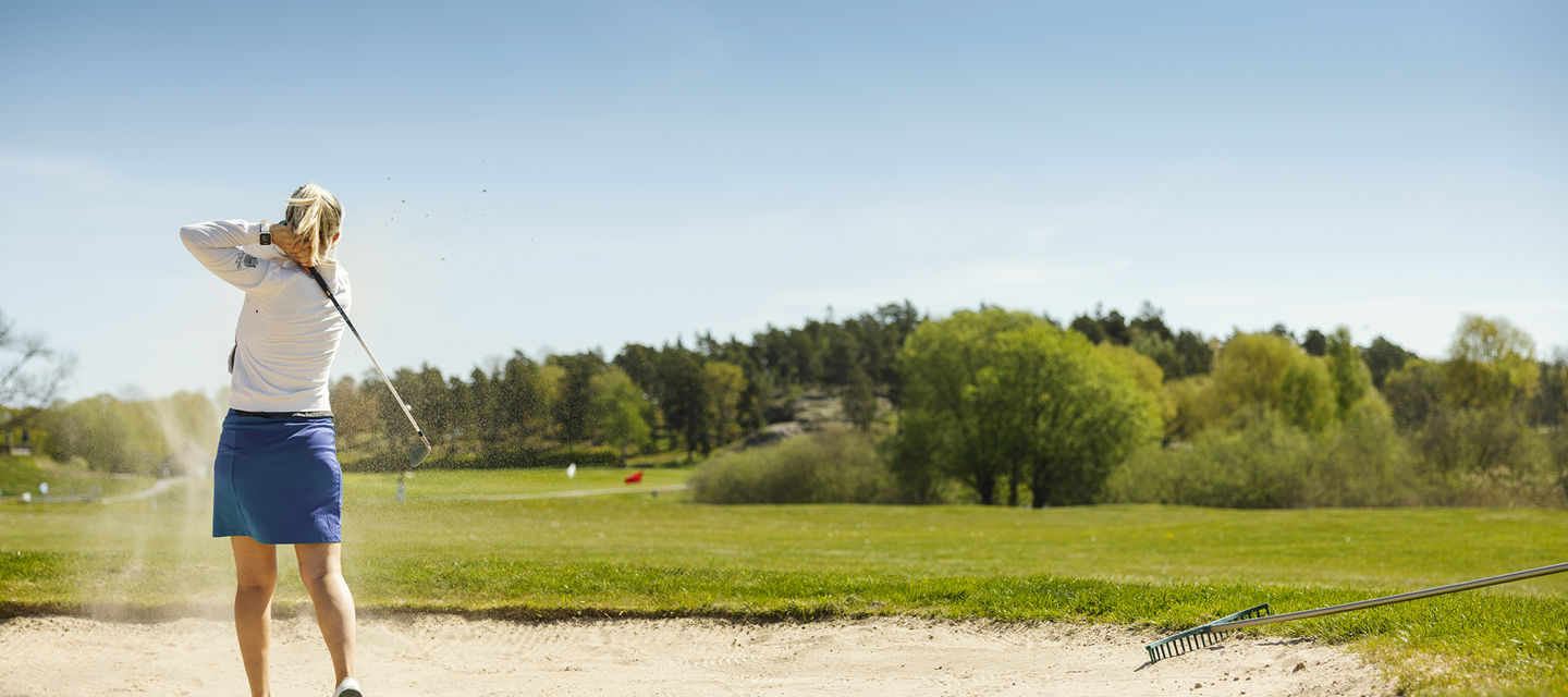 Kvinna spelar golf