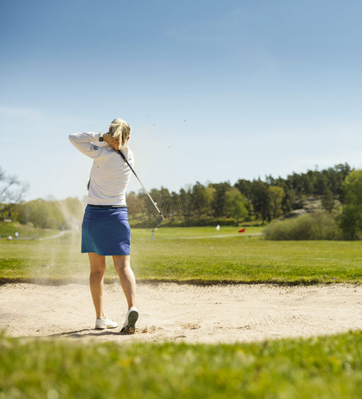 Kvinna spelar golf