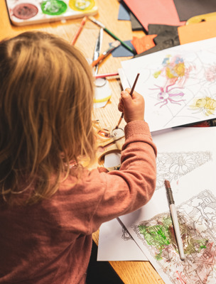 Ett barn pysslar och målar