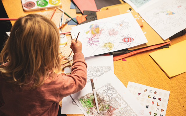 Ett barn pysslar och målar