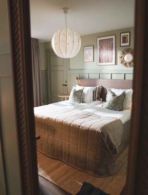 Rogivande hotellrum på Värmdö inrett med ljusa färger och mjuka textiler