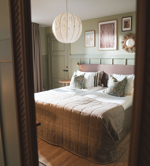 Rogivande hotellrum på Värmdö inrett med ljusa färger och mjuka textiler