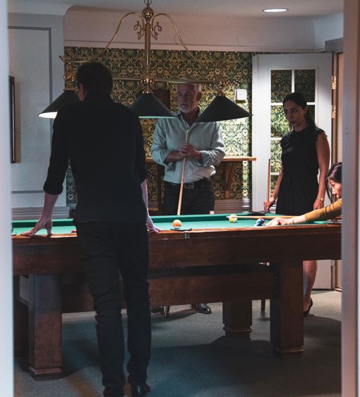 Grupp spelar biljard i vacker salong