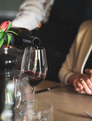 Servitör serverar vin i restaurangen