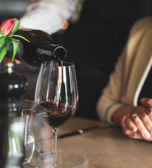 Servitör serverar vin i restaurangen