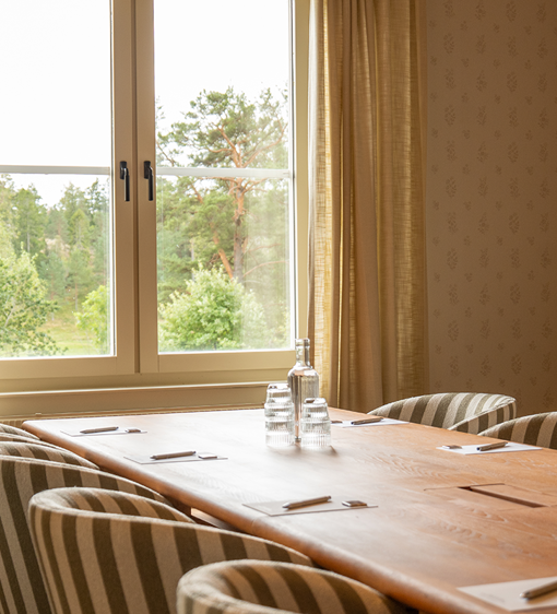 Konferensrum i ljusa färger, möblerad i styrelsesittning