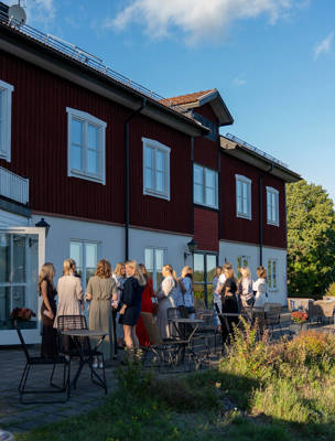 En grupp minglar på terrassen i solen