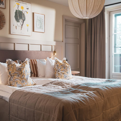 Bäddad hotellsäng i ett rum med tillhörande balkong