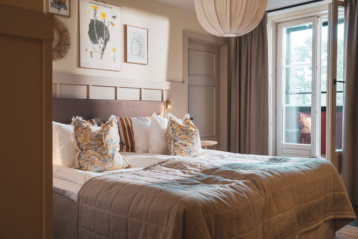 Bäddad hotellsäng i ett rum med tillhörande balkong