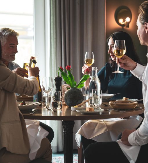 En grupp äter middag i hotellets restaurang och skålar med vin