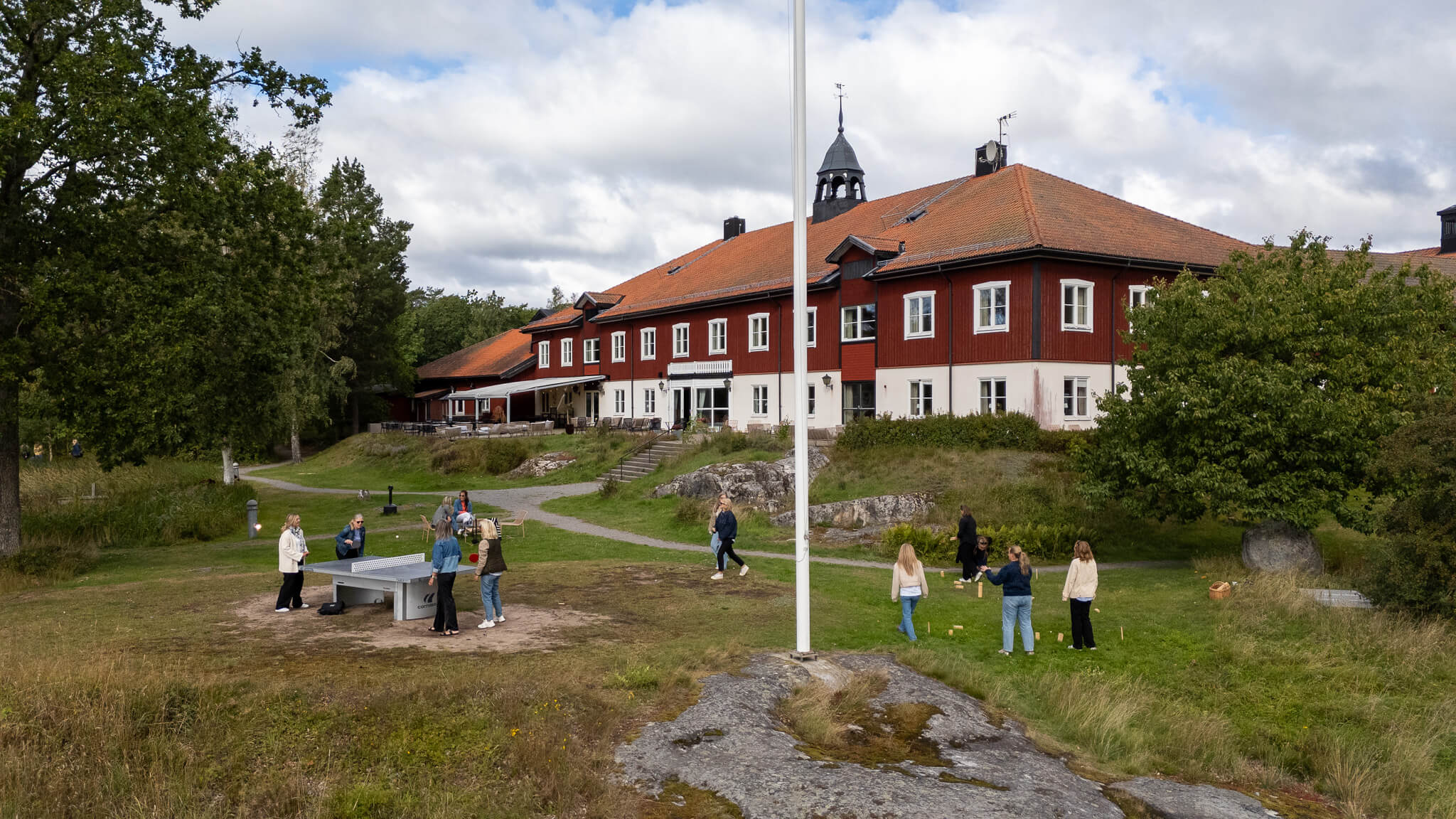 En grupp spelar pingis, boule och kubb utomhus