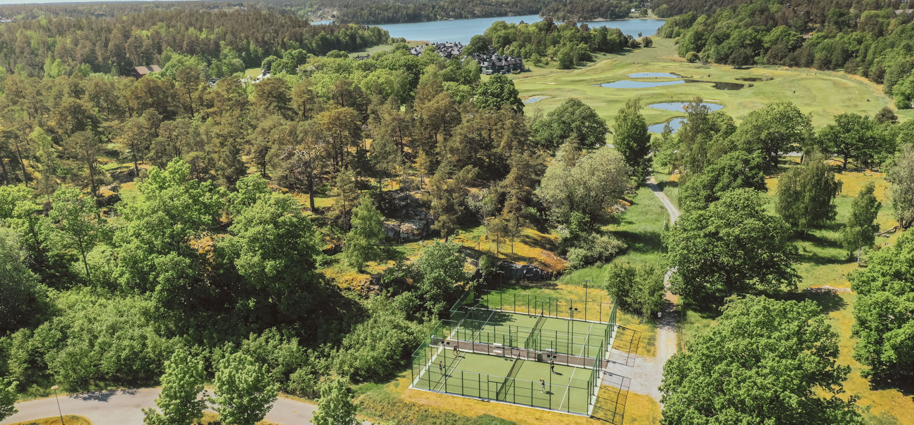 Spela padel på två padelbanor omgivna av grönskande miljöer på Värmdö